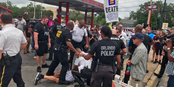 Watch as crowds cheer a homophobic protestor being arrested