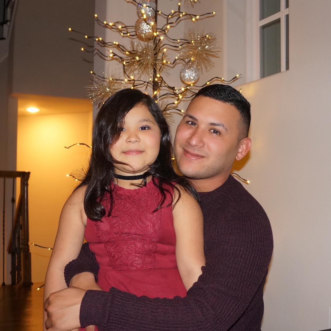 Juan and daughter with Christmas tree in background