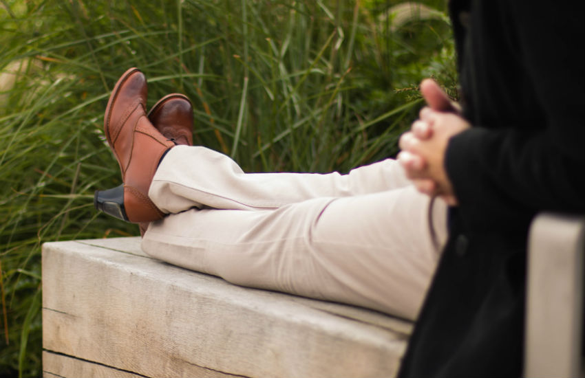 Man sitting on bench wearing high heel shoes