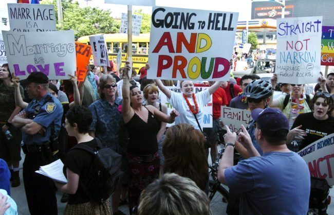 SEATTLE - MAY 1: Protestors hold signs and greet participants to a rally to affirm traditional marriage between a man and a woman on May 1, 2004 at Safeco Field in Seattle. The special speaker was James Dobson, founder of the evangelical Christian group called "Focus on the Family". The event was organized by local Christian groups and drew approximately 20,000 people as well as about 3,000 protestors, according to police. (Photo by Ron Wurzer/Getty Images)