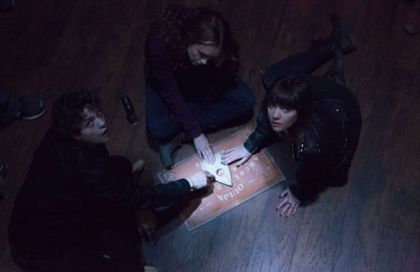 Three people using a ouija board in a seance