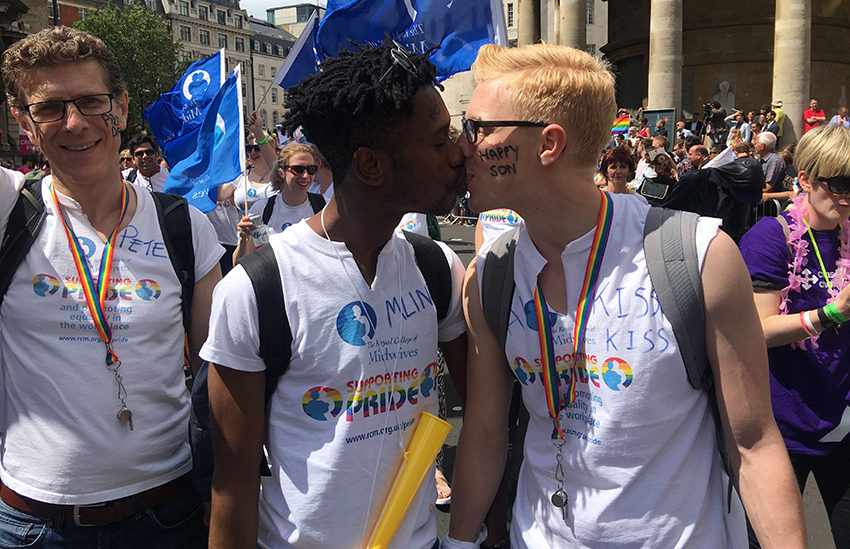 Young male couple kiss at Pride.