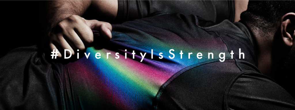 a bent over person whose black top is being pulled to reveal rainbow colours, text over the top says #diversityisstrength