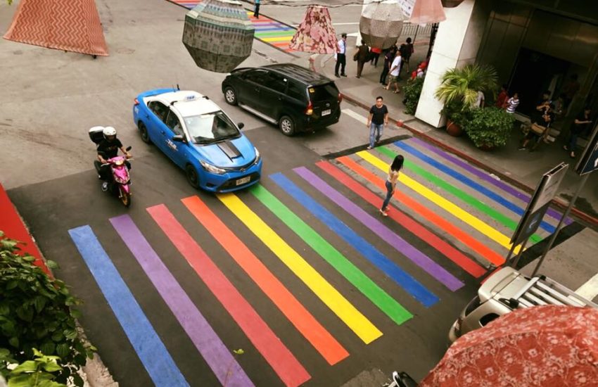 An overhead shot of a rainbow crossing, the lines are thin and there are cars waiting to cross
