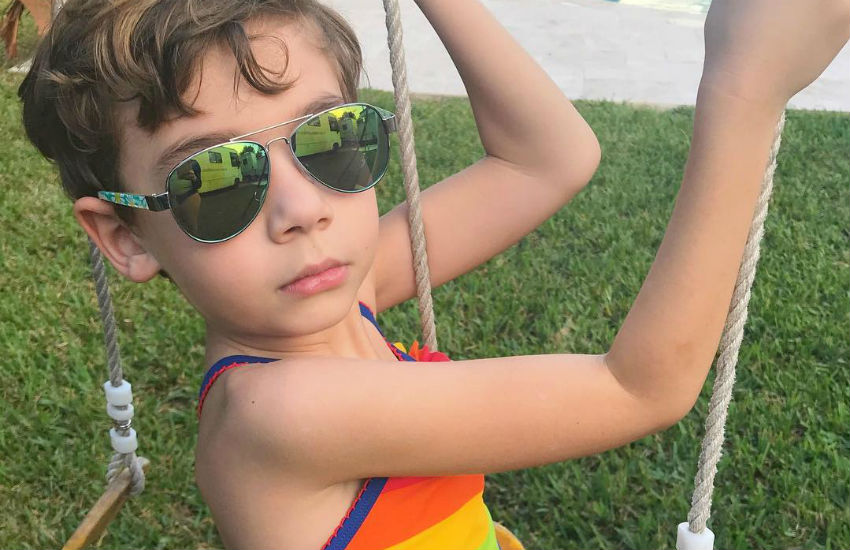 Cooper in a rainbow top on a swing
