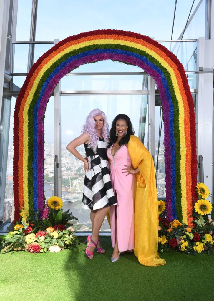 Micheal Twaits and Mzz Kimberley standing in front of a rainbow arbor.