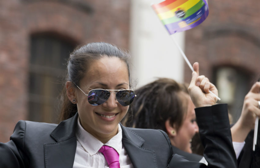Woman in suit and pink tie at a Pride event