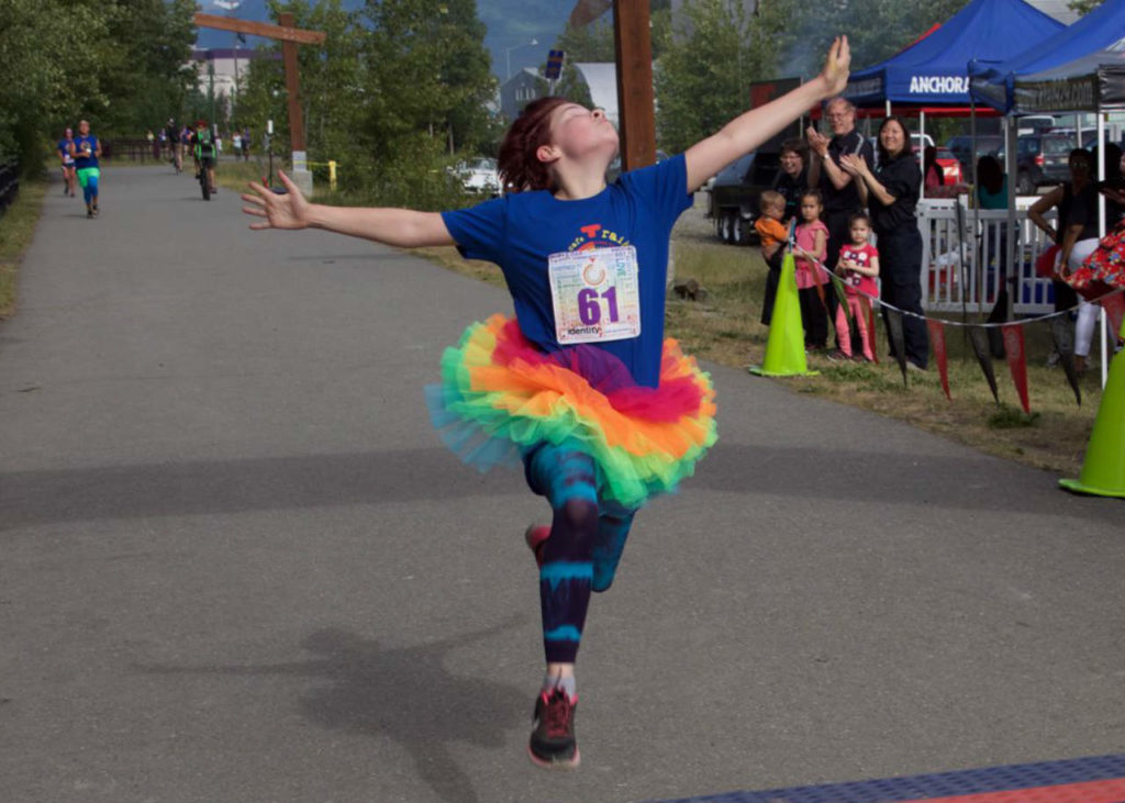 A runner getting to the finish line in style at Anchorage PrideFest