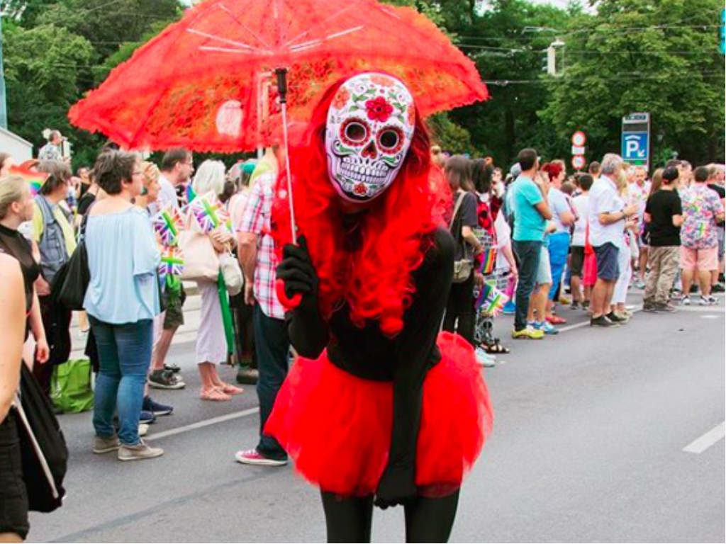 A marcher in costume wearing a Mexican skull mask.