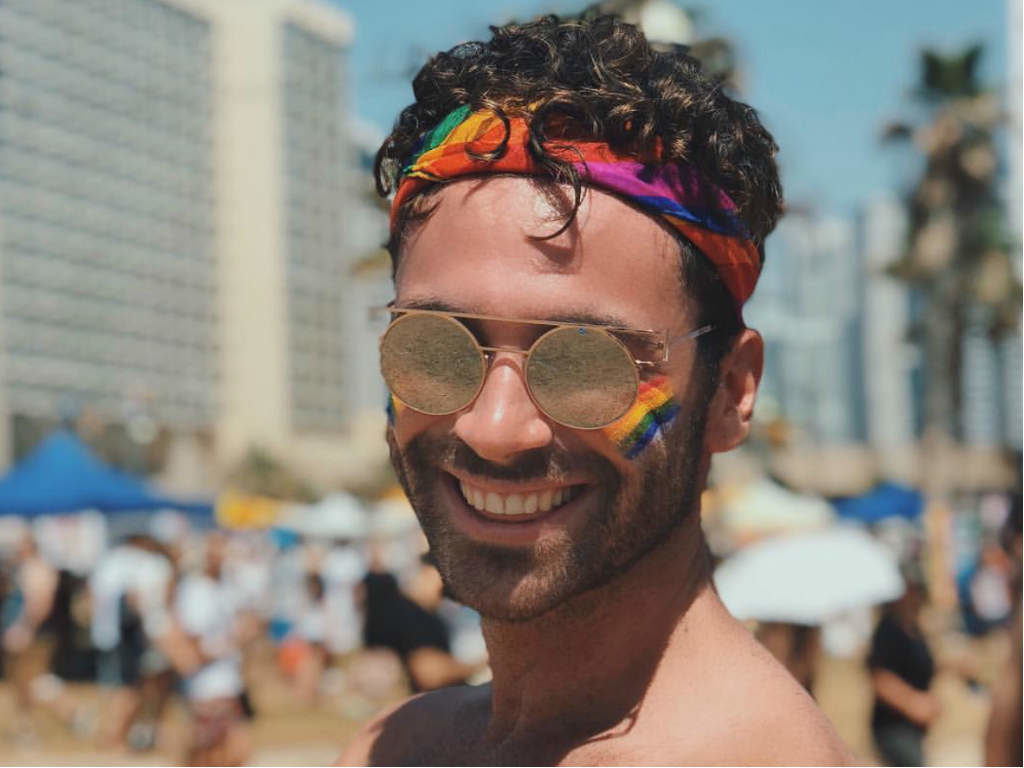 A man in sunglasses and rainbow headband at Tel Aviv Pride