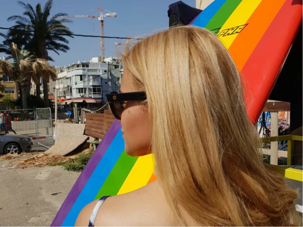 A girl with a rainbow surfboard at Tel Aviv Pride