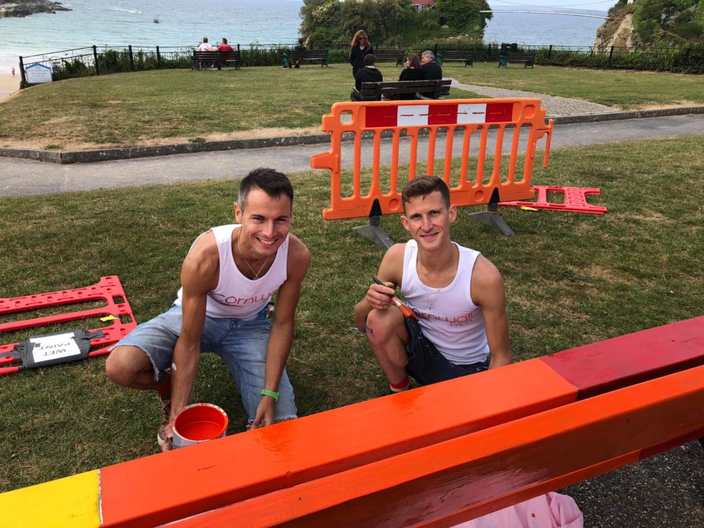 Two volunteers repainting the benches.