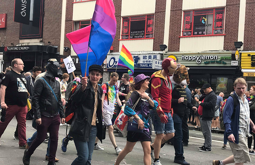 A marcher carries the flag for bi visibility at Birmingham Pride in England.