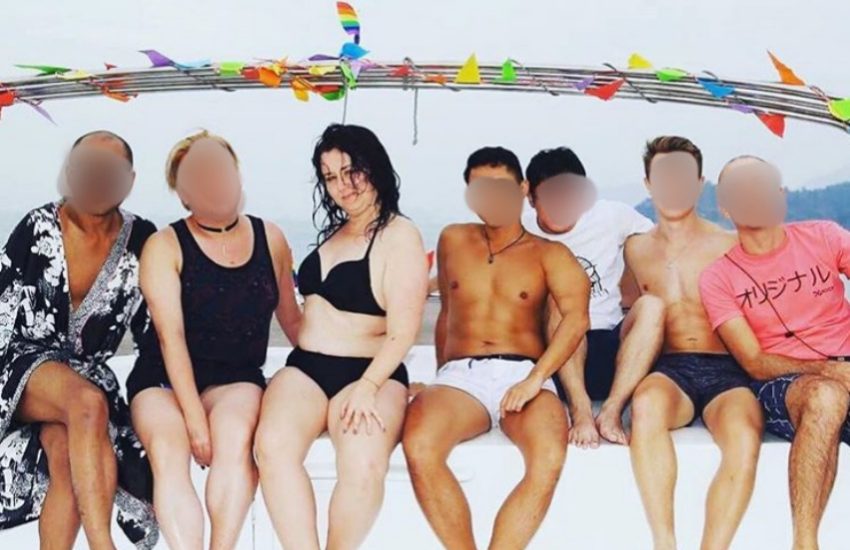 Shannon sits on a boat in a line of men whose faces are blurred out, she is wearing black bikini 