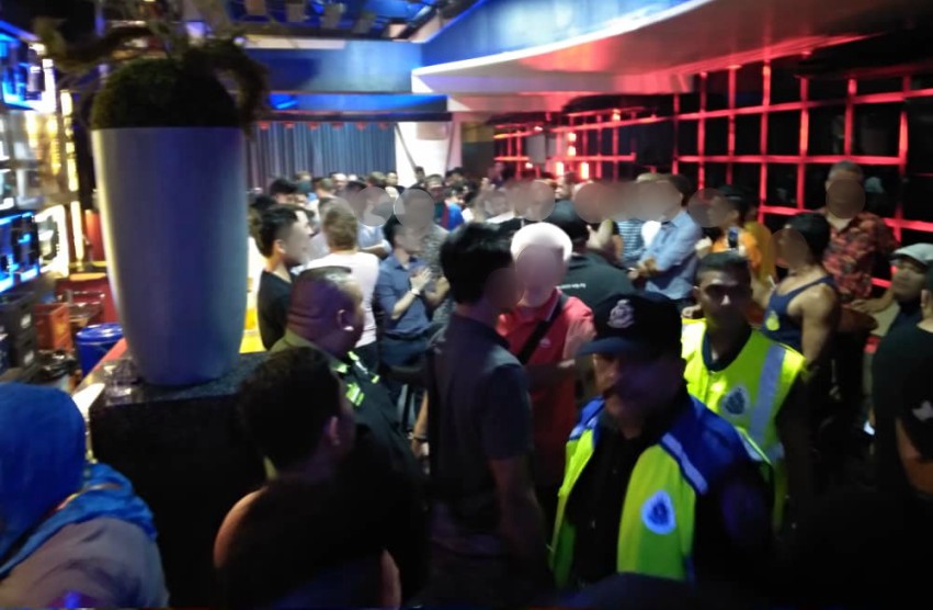 people stand around in a bar with police standing around in uniform