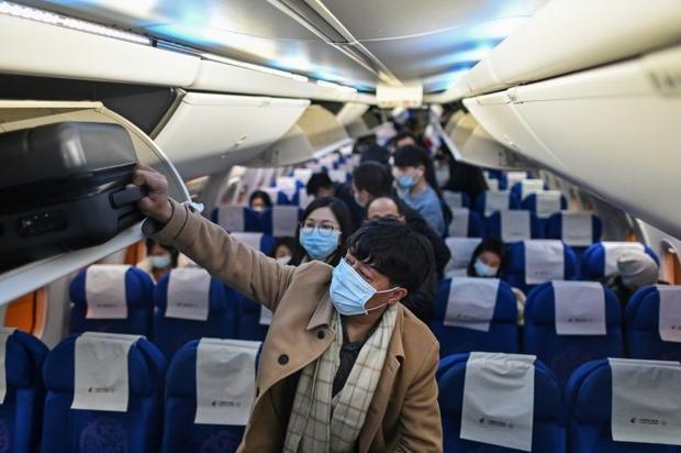 Passengers wearing protective facemasks as a preventive measure against Covid-19 leave a plane upon...